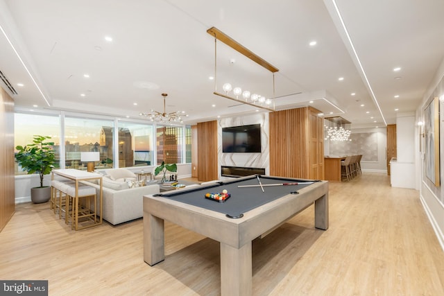 recreation room with bar area, an inviting chandelier, billiards, and light hardwood / wood-style flooring