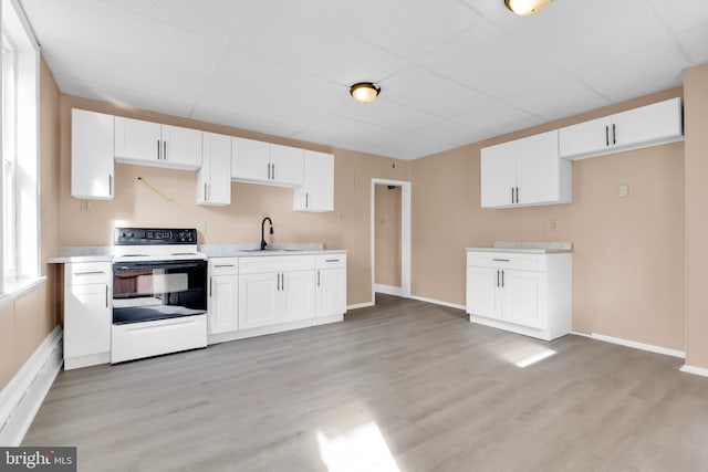 kitchen featuring white cabinets, electric range, light hardwood / wood-style flooring, and sink