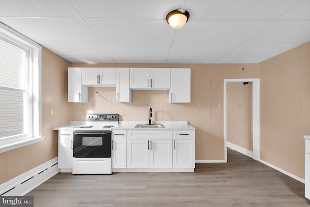 kitchen with white cabinets, white electric range, sink, light wood-type flooring, and a baseboard radiator