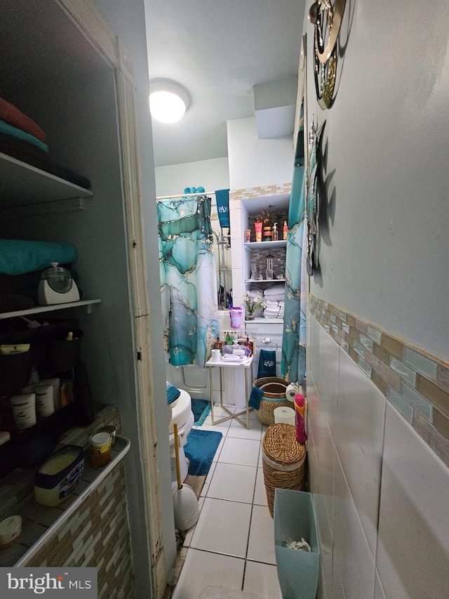 bathroom featuring tile patterned floors and tile walls