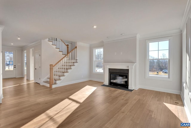 unfurnished living room with crown molding and light hardwood / wood-style flooring