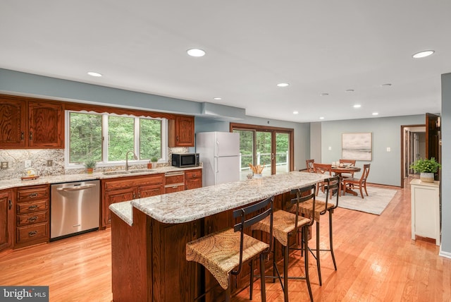 kitchen featuring light wood-type flooring, sink, a breakfast bar area, and stainless steel appliances