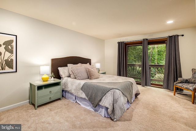 bedroom with access to outside and light colored carpet