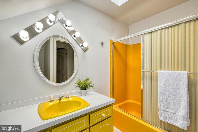 bathroom featuring vaulted ceiling with skylight, vanity, and shower / washtub combination