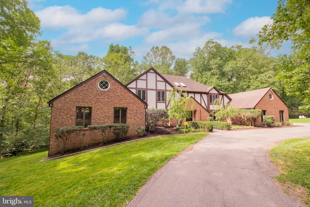 english style home featuring a front yard