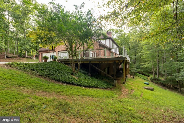 rear view of house with a wooden deck and a lawn