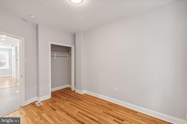 unfurnished bedroom featuring light hardwood / wood-style floors and a closet