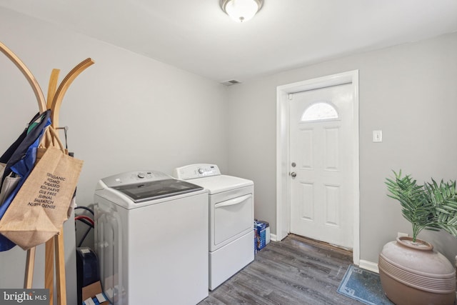 clothes washing area featuring washing machine and dryer and dark hardwood / wood-style flooring