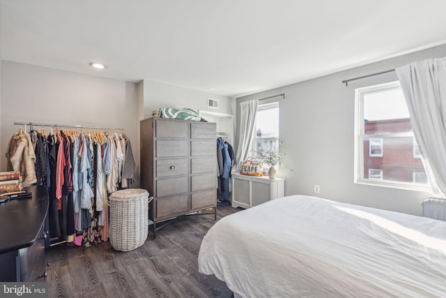 bedroom with multiple windows and dark hardwood / wood-style floors