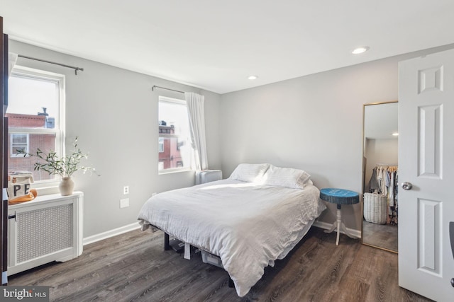 bedroom with radiator and dark hardwood / wood-style floors