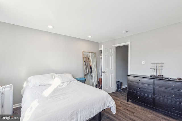 bedroom with radiator and dark wood-type flooring