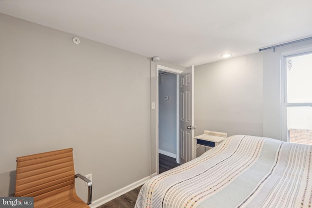 bedroom with dark wood-type flooring and multiple windows