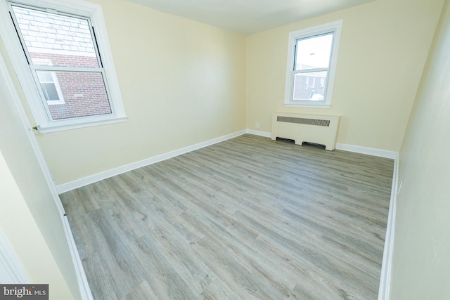 empty room with radiator and light wood-type flooring