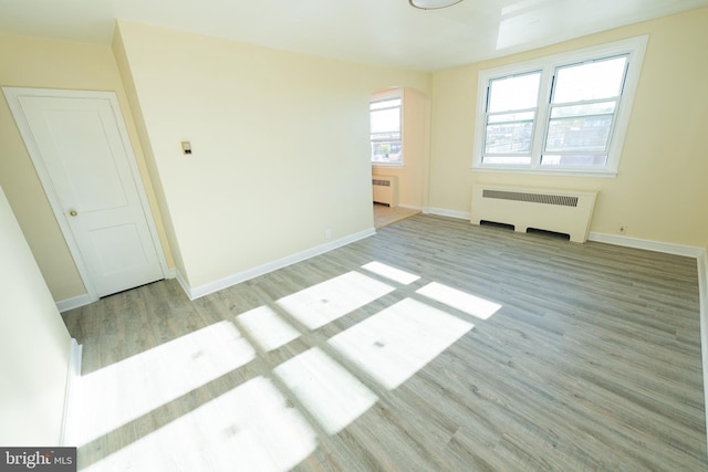 unfurnished room with light hardwood / wood-style floors and radiator