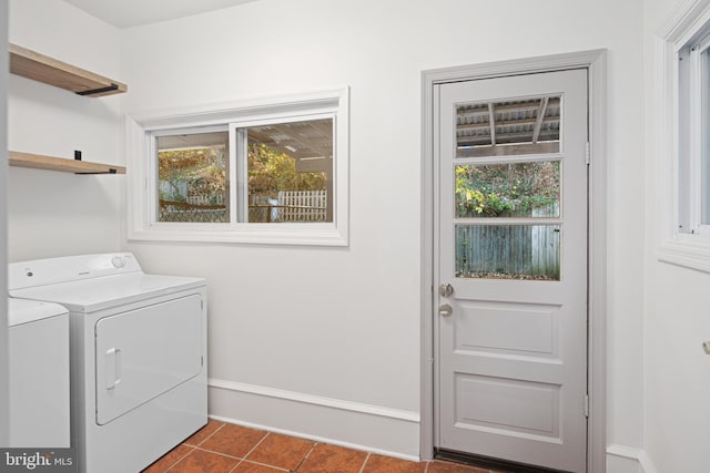 laundry area featuring washing machine and dryer and dark tile patterned floors