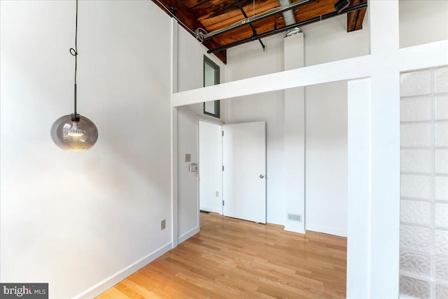 interior space with wooden ceiling, a towering ceiling, and wood-type flooring