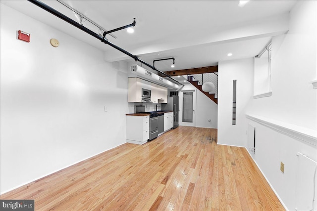 interior space featuring white cabinets, light wood-type flooring, and appliances with stainless steel finishes