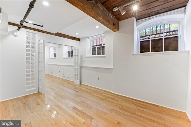 unfurnished living room featuring beamed ceiling, light wood-type flooring, and track lighting