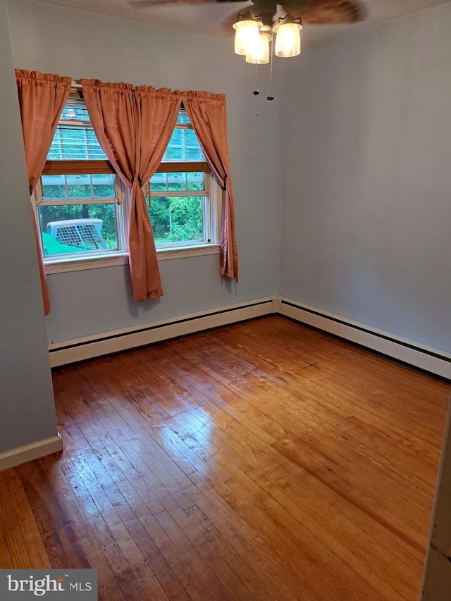 unfurnished room with a baseboard radiator, hardwood / wood-style flooring, and ceiling fan