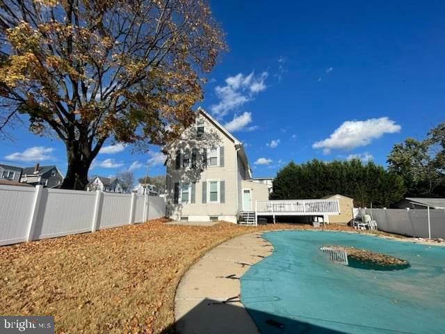 rear view of house featuring a swimming pool side deck