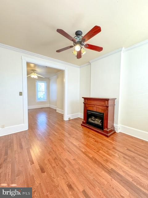 unfurnished living room featuring ornamental molding, light hardwood / wood-style floors, and ceiling fan