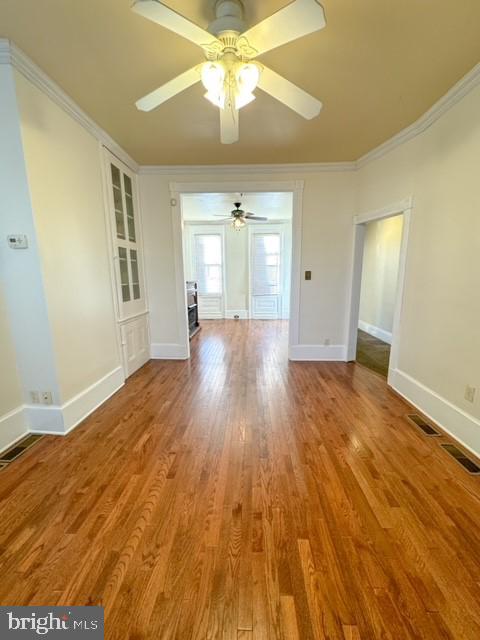 unfurnished room featuring ceiling fan, light hardwood / wood-style floors, and ornamental molding