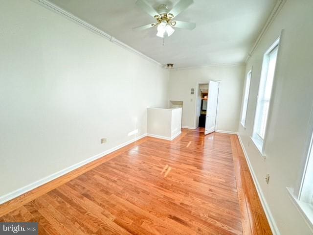 unfurnished room with ornamental molding, light wood-type flooring, and ceiling fan