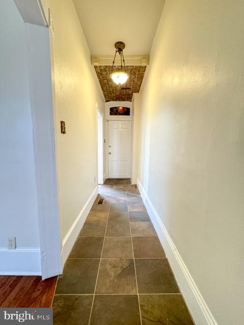 hall with dark tile patterned flooring