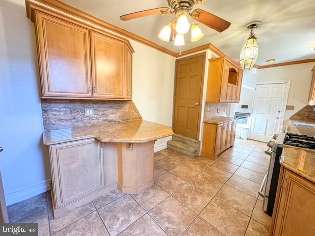 kitchen with stainless steel range with gas cooktop, crown molding, kitchen peninsula, and decorative backsplash