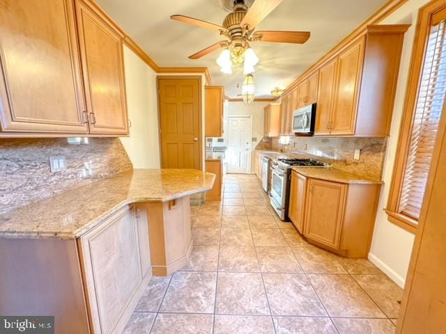 kitchen with stainless steel appliances, backsplash, light tile patterned floors, a breakfast bar, and ceiling fan