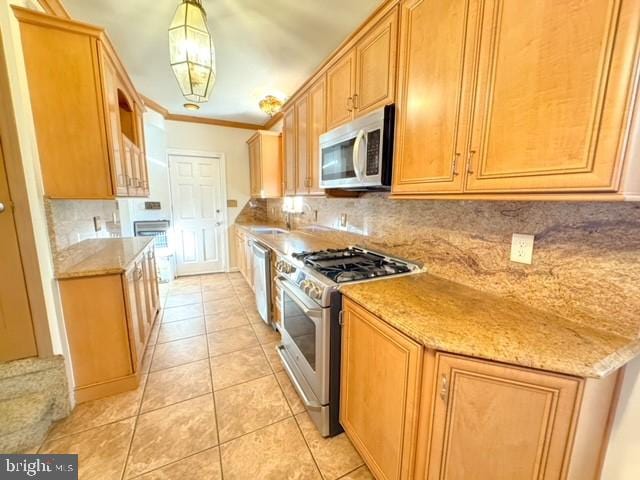 kitchen with tasteful backsplash, hanging light fixtures, light tile patterned floors, and stainless steel appliances