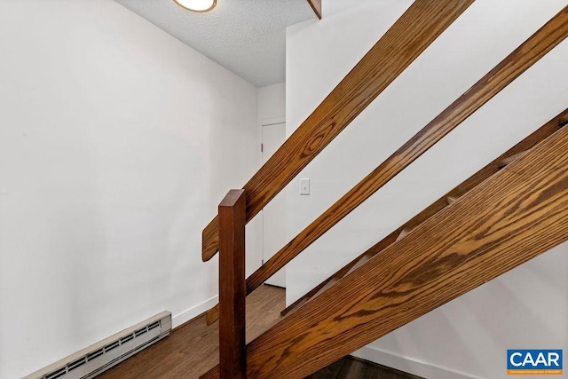 stairway with hardwood / wood-style floors and a baseboard radiator