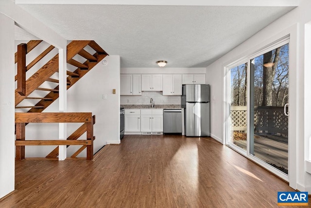 kitchen with stainless steel appliances, a textured ceiling, sink, white cabinets, and dark wood-type flooring