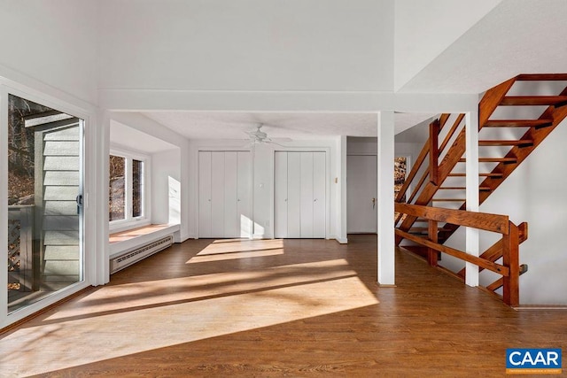 interior space featuring hardwood / wood-style flooring, ceiling fan, and a baseboard heating unit