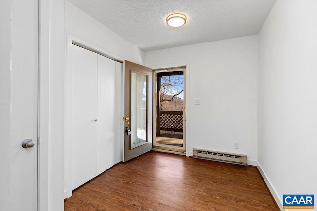 entrance foyer with dark wood-type flooring, a textured ceiling, and a baseboard radiator