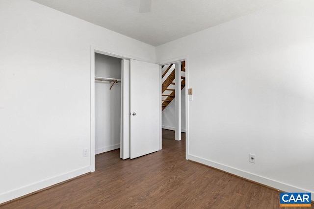 unfurnished bedroom featuring ceiling fan, a closet, and dark hardwood / wood-style flooring