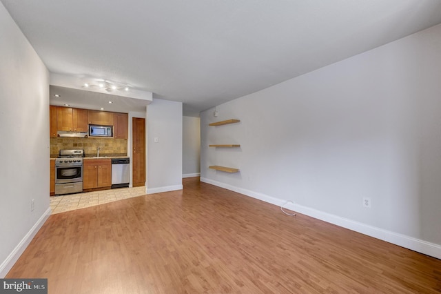 unfurnished living room with light hardwood / wood-style floors and sink