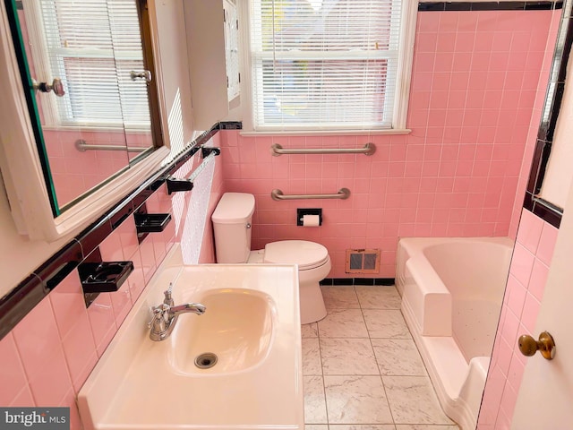 full bathroom featuring tile patterned floors, sink, separate shower and tub, toilet, and tile walls