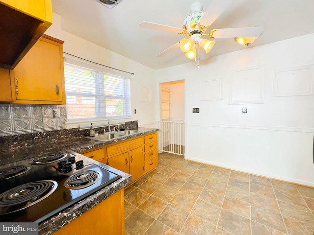 kitchen featuring ceiling fan, black electric cooktop, sink, and tasteful backsplash