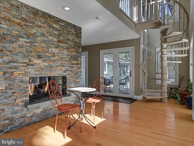 interior space with light wood-type flooring, a multi sided fireplace, and crown molding