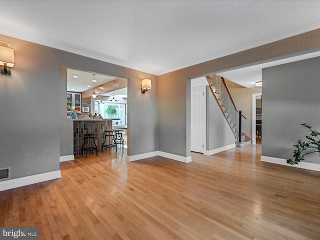 interior space with light wood-type flooring and crown molding