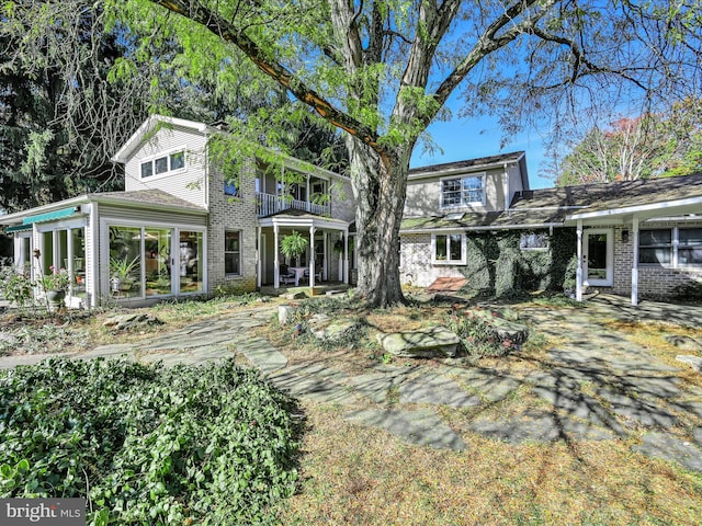 back of house featuring a sunroom and a balcony