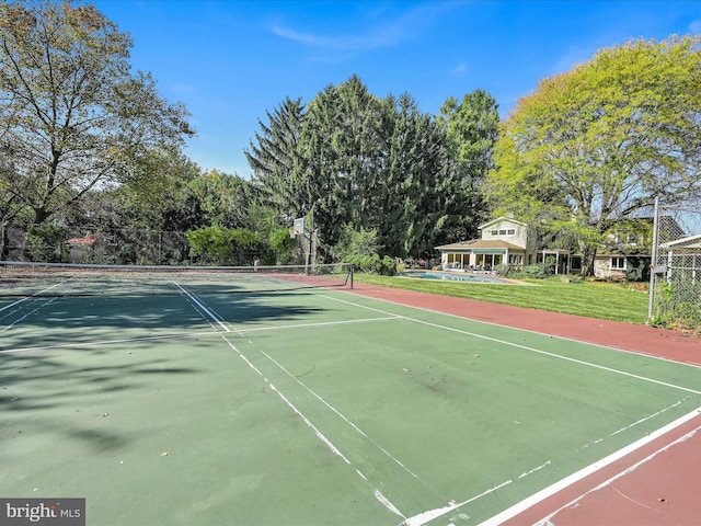 view of tennis court with basketball hoop