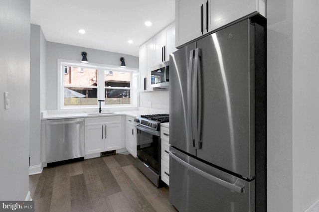 kitchen with white cabinets, stainless steel appliances, dark wood-type flooring, and sink