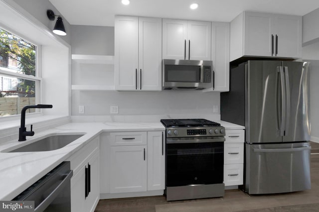 kitchen featuring white cabinets, appliances with stainless steel finishes, and sink