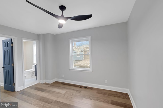 unfurnished bedroom featuring ceiling fan, light wood-type flooring, and ensuite bath