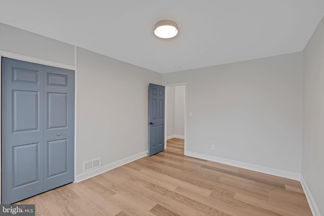 unfurnished bedroom featuring a closet and light hardwood / wood-style floors