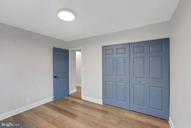 unfurnished bedroom with light wood-type flooring and a closet