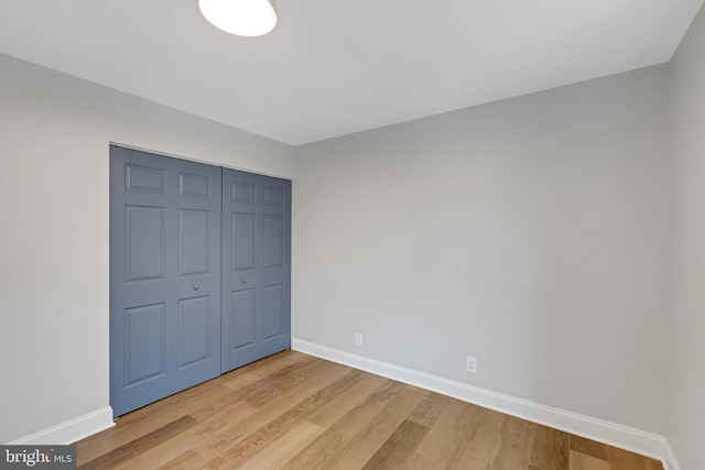 unfurnished bedroom featuring wood-type flooring and a closet