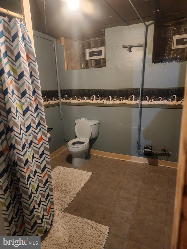 bathroom with toilet, tile patterned flooring, and walk in shower